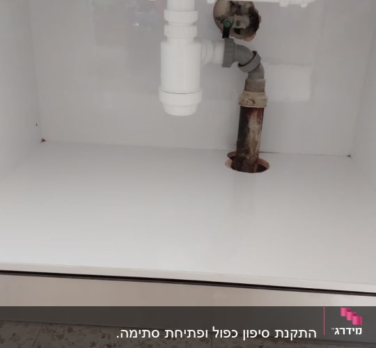 צנרת פלסטיק לבנה מתחת לכיור מטבח